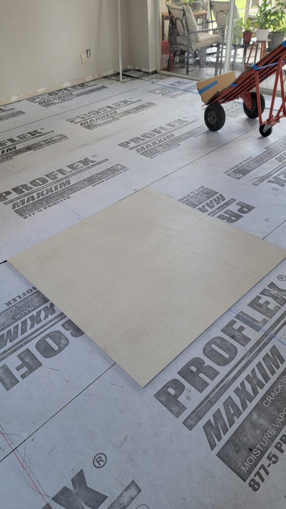 Large-format porcelain tile laid out over a crack-isolation membrane during floor preparation