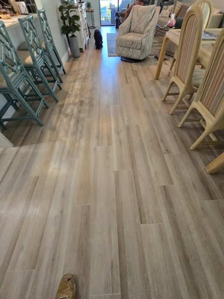 Finished wood-look porcelain plank flooring running through the dining and living areas of an Ave Maria home