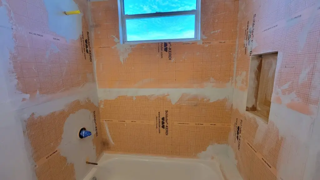 Schluter KERDI waterproofing membrane installed around a guest bathtub and shower walls in Naples, Florida.